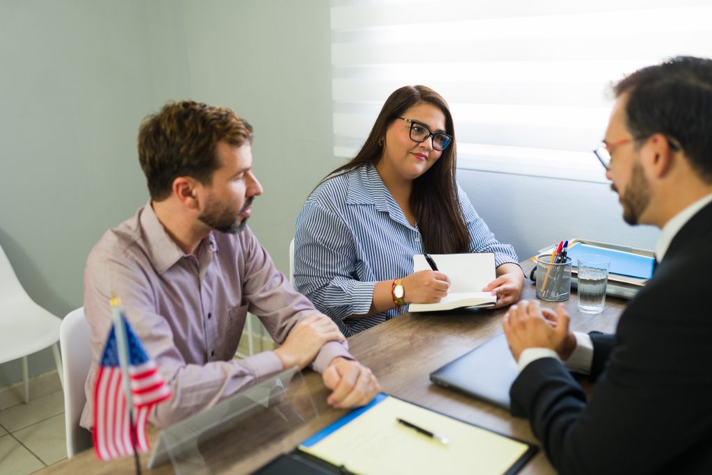Couple discussing green card related issues with immigration lawyer at Abbasi Immigration Law Firm
