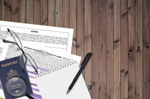 Department of State form DS60 Affidavit Regarding a change of name lies on table and ready to fill. The name change is happening during an ongoing immigration case